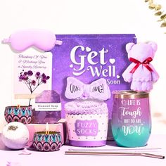 a purple gift box filled with lots of different items and decorations next to a pink teddy bear