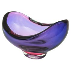 a purple and black glass bowl sitting on top of a table