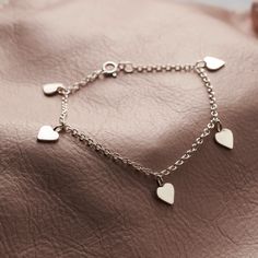 The beautiful Sterling Silver Heart Station Bracelet is handcrafted in our Brighton workshop from Sterling silver. This delicate bracelet features five mini heart pendants in a fixed position on a fine trace chain. This is the perfect gift for lovers of dainty jewellery that can be worn every day. Each bracelet is individually handmade to order and comes presented in a stylish Posh Totty Designs giftbox.Made from: 925 Sterling silverDimensions: Each heart pendant measures approximately 7mm acros Fine Bracelet, Posh Totty, Station Bracelet, Heart Pendants, Heart Tag, Bracelet Chain, Silver Chain Bracelet, Station Necklace, Mini Heart