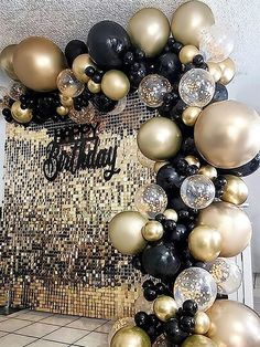 a black and gold balloon arch with balloons