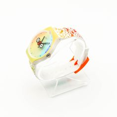 Authentic 2018 Swatch New Gent Special Whats Yo Face Watch SUOZ303. The Swatch Club Special What Yo Face was designed by artist Ton Mak, the creator of the Flabjacks collection. Hence you will find those cute little figures in orange and green on the white silicone strap. The plastic case is green and the dial is rainbow colored with two eyes and red lips in the center. The waterproof watch has a precise ETA quartz movement with a battery. This item is new in its original box. ﻿﻿﻿﻿﻿﻿﻿﻿﻿﻿﻿Everyon Multicolor Analog Watches For Gift, Multicolor Analog Watches As Gift, Gift Multicolor Analog Watches, Trendy Multicolor Quartz Watches, Trendy Multicolor Watches As Gifts, Trendy Green Watches As Gift, Casual White Watches For Gifts, Casual White Watches As Gifts, Little Figures