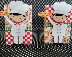 two paper dolls are standing next to each other on a black and white checkered tablecloth