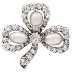 A Victorian pearl and diamond cluster clover leaf brooch, each petal set with a pear natural shaped pearl to the centre of an old-cut diamond set open cluster surround, with diamond-set stalk, the diamonds estimated to weigh a total of 3 carats all set in silver to a yellow gold mount with brooch fitting, circa 1880, measuring approximately 3.3 x 3.3cm, gross weight 11.2 grams. Unmarkedtested as 18ct gold and Silver. A Victorian pearl and diamondclover leaf brooch in Good condition, with histori Diamond Brooches, Leaf Brooch, Antique Brooches, Diamond Brooch, Jewellery Shop, Pearl Brooch, Natural Pearl, Women Diamond, Pearl Diamond