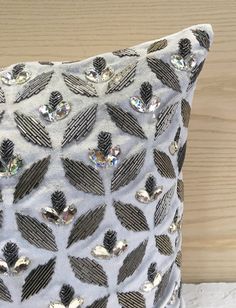 a white and black pillow with silver sequins