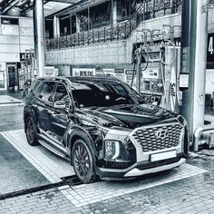 an suv is parked in front of a gas station