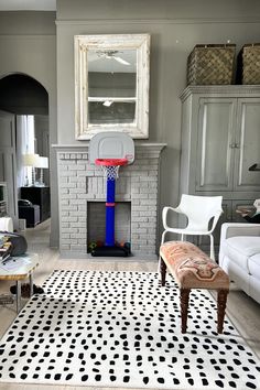 a living room filled with furniture and a basketball hoop in the middle of the room