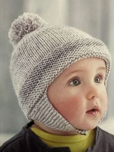 a baby wearing a knitted hat with a pom - pom