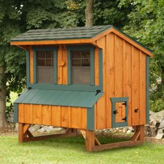 a small wooden chicken coop sitting in the grass