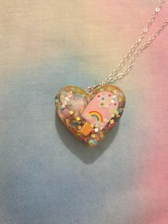 This is a handmade epoxy resin necklace with a silver 18 inch chain. The charm is approximately 3.5 cm wide. This is an adorable necklace that would fit with a range of outfits and styles. It features a ice cream motif with small colourful charms and lots of holographic glitter to catch the eye! The backing is sparkly yellow. Each item is one of a kind and handmade - so each one is completely unique and special! Ice Cream Kawaii, Decora Style, Rainbow Ice Cream, Resin Necklace, Holographic Glitter, Resin Jewelry, Epoxy Resin, Charm Necklace, Heart Shapes