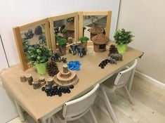 a wooden table topped with lots of fake plants and animals on top of it's sides