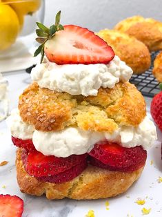 strawberry shortcakes stacked on top of each other with whipped cream and strawberries