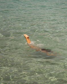 a man swimming in the ocean with his head above the water