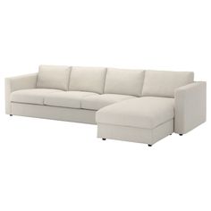 a white couch with a chaise lounger on the bottom right side and an ottoman in the middle