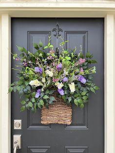 a basket filled with flowers hanging from the side of a door