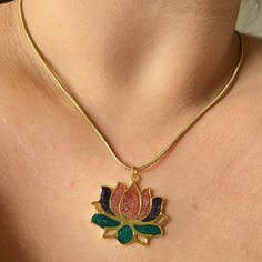 Introducing our enchanting Lotus Flower Necklace, a true embodiment of elegance and craftsmanship. Handcrafted with precision and care, this exquisite piece features a stainless steel chain measuring 45 cm in length, providing both durability and sophistication. At its focal point rests a mesmerizing lotus flower pendant, delicately crafted from brass and adorned with a radiant 24K gold plating. Each petal of the lotus blooms with vibrant shades, brought to life by resin pigments in hues of majestic purple, soft pink, and verdant green. The lotus, revered for its symbolism of purity and enlightenment, adds a touch of grace and serenity to any ensemble. With dimensions approximately 3.2 cm in size, this pendant exudes understated elegance and timeless beauty. Whether you're treating yoursel Gold Flower Jewelry For Meditation, Gold Spiritual Flower Necklaces, Gold Spiritual Flower Necklace, Spiritual Gold Flower Necklaces, Spiritual Gold Flower Necklace With Flower Charm, Gold Flower Pendant Necklace Gift For Her, Lotus Flower Pendant, Lotus Flower Necklace, Verdant Green