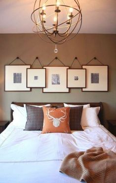 a bed with pillows and pictures hanging on the wall above it's headboard