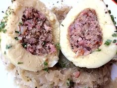 an open - faced sandwich with meat and onions on top of rice, sits on a white plate