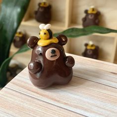 a brown bear figurine sitting on top of a wooden table