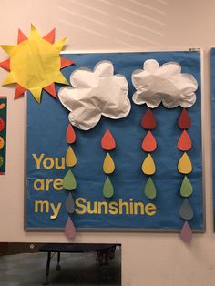 a bulletin board with paper rain drops and you are my sunshine