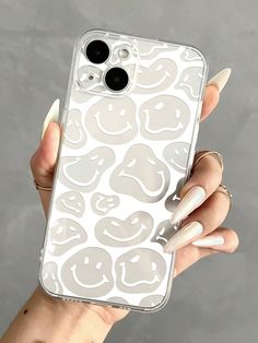 a woman's hand holding an iphone case with smiley faces on it