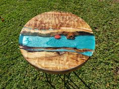 a wooden table sitting on top of a lush green field