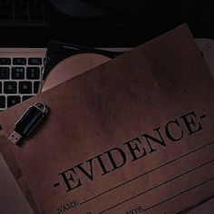 a brown paper with the word evidence on it next to a computer keyboard and mouse