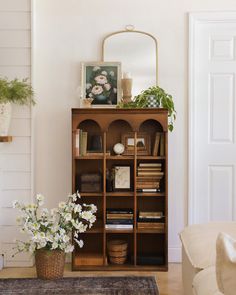 a living room with a book shelf and flowers