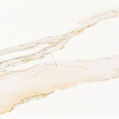 a white marble counter top with gold veining on the edges and an abstract design