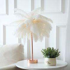 a white table with a potted plant on it and a light up palm tree