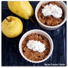 three small bowls filled with food next to a pear and another one has whipped cream on top