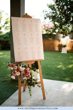 a sign with flowers on it sitting in the grass