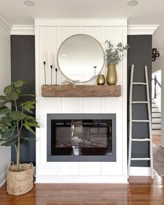 a living room with a fireplace, mirror and ladder