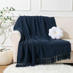 a white flower sitting on top of a blue blanket next to a chair and rug