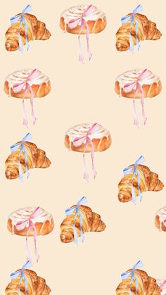 a watercolor painting of croissants with icing and bows on them