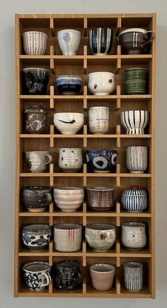 a wooden shelf filled with lots of bowls