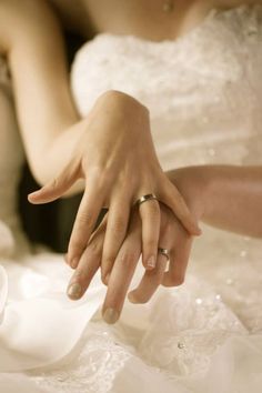 a close up of a person's hand with wedding rings