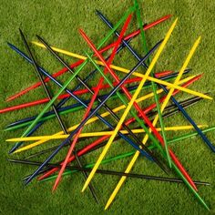 a pile of colored sticks laying on top of green grass