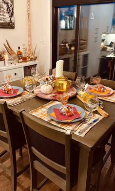 a dining room table set with plates and glasses