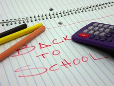 two pencils and a calculator sitting on top of a notebook