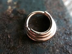 I made this lovely septum ring entirely from solid 14 karat rose gold. It is made to look layered. Twist open and closed to keep the circle shape, the ends are smooth for easy insertion. Can be worn in a variety of piercings. This nose ring is finished with a shiny high polish. Choose your gauge and inside diameter for a custom fit! Comes beautifully packaged and ready for gift giving! Check out my other nose rings here: https://www.etsy.com/shop/DinanRings?section_id=13671263&ref=shopsectio Nose Rings, Septum Piercing, Nose Ring Stud, Ear Piercing, Gold Dipped, Circle Shape, Tragus, Conch, Piercing Jewelry