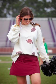 Be game day ready for any team in this neutral sweatshirt featuring sequin footballs! Cream colored and fits loose so you could size down. Model is wearing size small. Materials: Rayon, polyester, spandex. Fit: Small 2-4 medium 6-8 large 10-12 xl 14-16 2X 18 White Sports Fan Top For Fall, White Tops For Fall Sports Fans, Team-colored Tops For Sports Events In Fall, White Sports Fan Sweatshirt For Fall, Casual Tops For Cheerleading In Fall, Fall School Spirit Team-colored Tops, Sporty Sweatshirt For Football Season Cheerleading, Sporty Tops For Game Day In Fall, Varsity Sweatshirt For Cheerleading In Fall