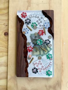 a white tray with some casino chips and money on it, sitting on top of a wooden table