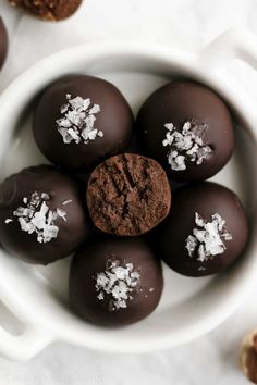 chocolate truffles with powdered sugar in a white bowl on a marble surface