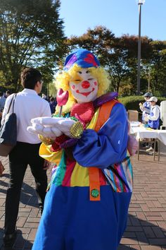 a man dressed as a clown holding something in his hand