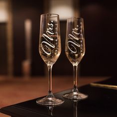 two wine glasses sitting on top of a table