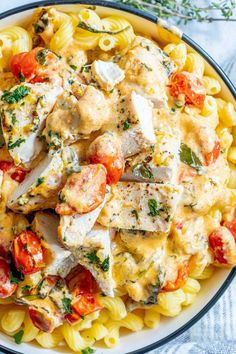 a plate of pasta with chicken and tomatoes