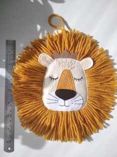 a close up of a stuffed animal on a white surface next to a measuring ruler