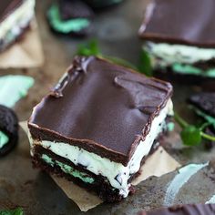 there is a piece of cake with chocolate and mints on the table next to cookies