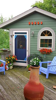 a potted plant sitting on top of a wooden deck next to two blue chairs