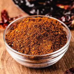 a bowl filled with spices sitting on top of a wooden table